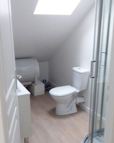 La même pièce devenue salle de bain, WC, chauffe-eau et douche sous la fenêtre de toit