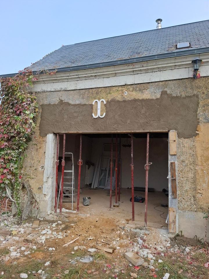 Façade en pierre ouverte et soutenue par des étais pendant un chantier
