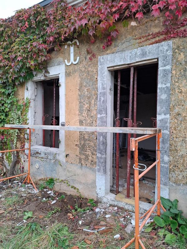 Ouvertures dans un mur en pierre, étais et échafaudage