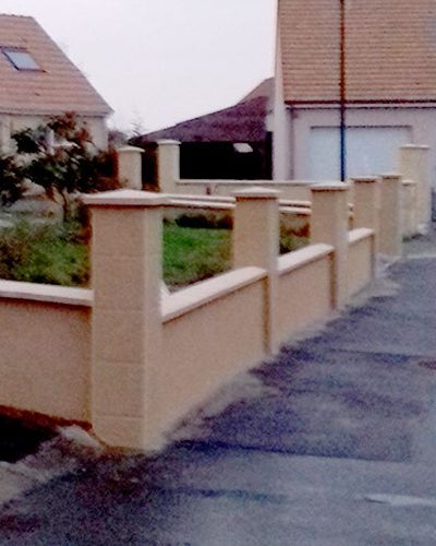 Le muret enduit avec ses piliers et chapeaux