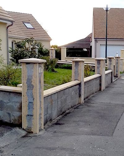 Muret brut en parpaings le long d'un trottoir